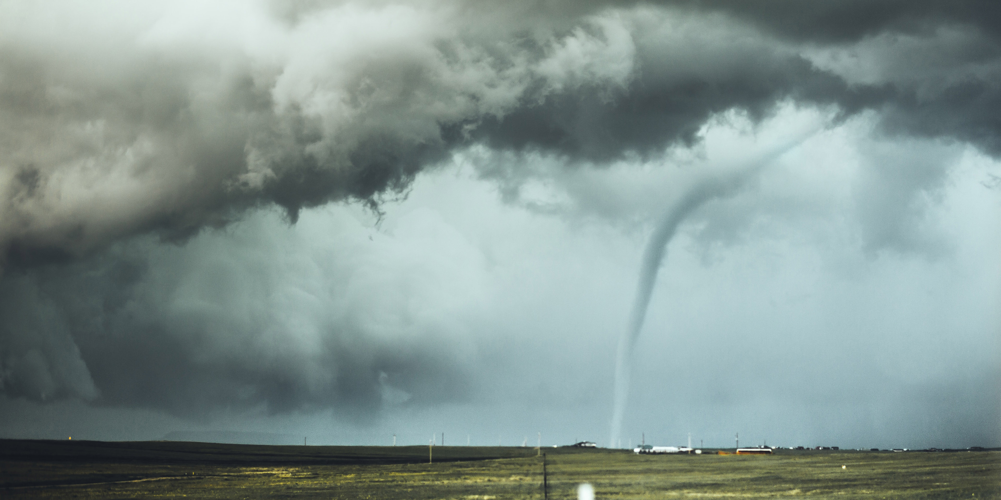 Tornado funnel cloud over farmland